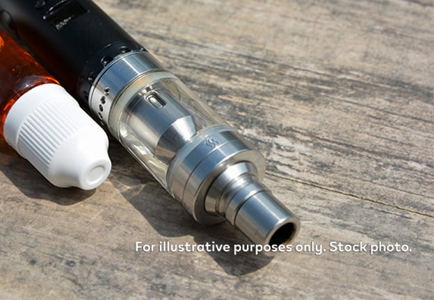 Vape next to bottle of e-liquid